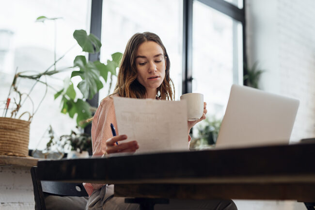 Objetivo para currículo Mulher sentada em frente ao notebook avaliando seu currículo