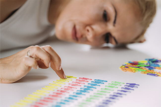 perfeccionismo mulher colocando clips em ordem de cor