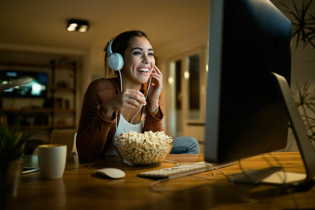 imagem mulher comendo pipoca em frente a tv